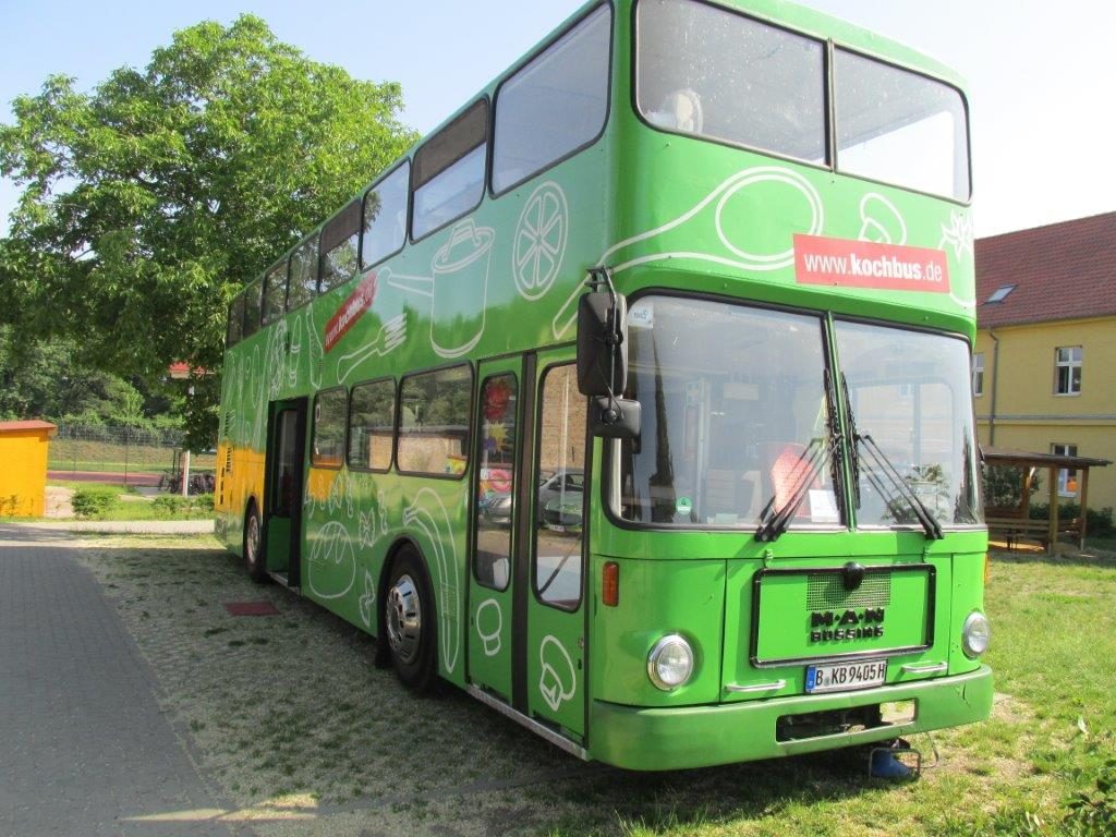 Der grüne Kochbus steht bei sommerlichem Wetter auf dem Gelände der Grundschule Jeserig