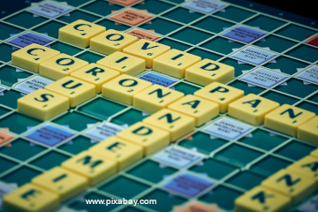 Ein Scrabble-Spielbrett mit den Worten "COVID", "CORONA", "VIRUS", "PANDEMIE" und den Silben "PAN" (von "Panik") und "ANK" (von "krank")