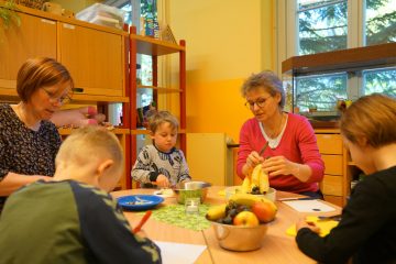 Staatssekretärin Antje Töpfer und Maren Daenzer-Wiedmer beim gemeinsamen Obst-Schnippeln mit den Kindern der Kita Waldhaus in Potsdam